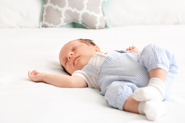 Cute little baby lying on bed at home