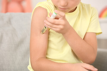 Little diabetic boy giving himself insulin injection at home