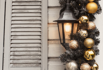 House new year decorations in gold and silver colors. Background christmas wall with street lamp