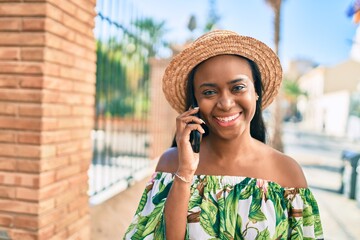 Young african american tourist woman on vacation smiling happy talking on the smartphone at the city.