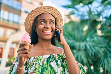 Young african american tourist woman on vacation Talking on the smartphone and eating ice cream at the city.