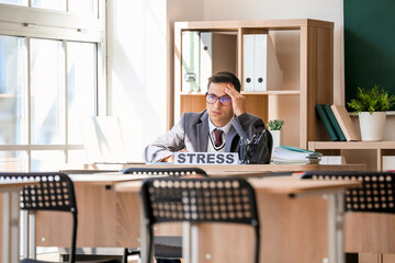 Stressed young male teacher in classroom