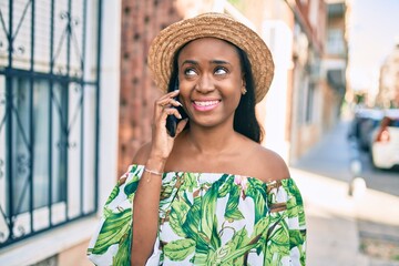 Young african american tourist woman on vacation smiling happy talking on the smartphone at the city.