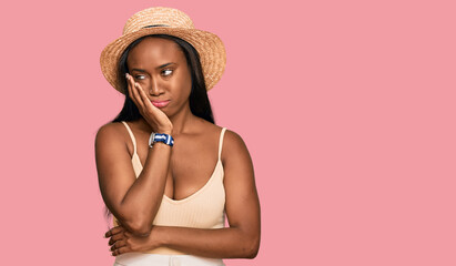 Young black woman wearing summer hat thinking looking tired and bored with depression problems with crossed arms.