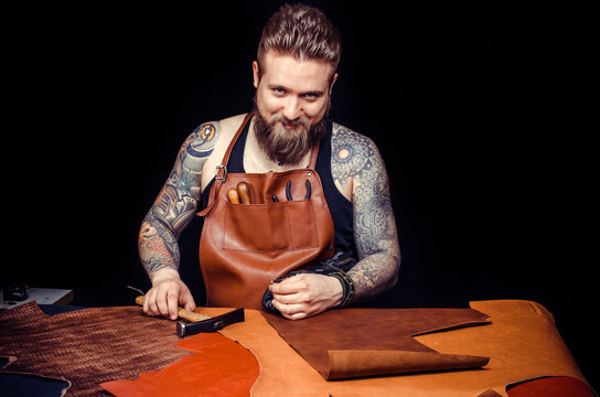 Leather Craftsman producing a leatherwork at his desk