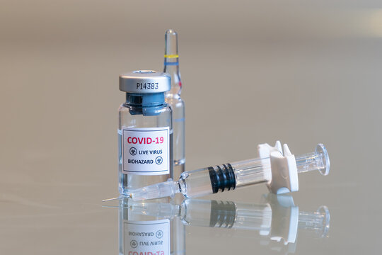 A Closeup Vial Of COVID-19 Coronvavirus Live Virus Biohazard Culture With A Syringe On The Right And Needle Tip In The Front - 091