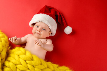 Cute little baby in Santa hat on color background