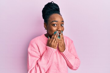 Young african american woman wearing casual winter sweater laughing and embarrassed giggle covering...