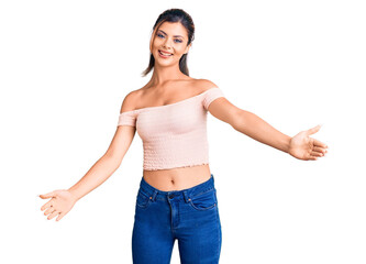 Young beautiful woman wearing casual clothes looking at the camera smiling with open arms for hug. cheerful expression embracing happiness.