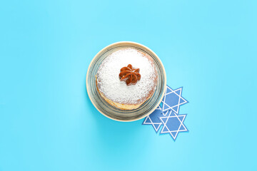 Tasty donut for Hanukkah on color background