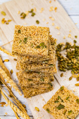 Multigrain Cereal Crunchy Squares Bars with Pumpkin Seeds Background. Healthy Bar Snack. Selective focus.