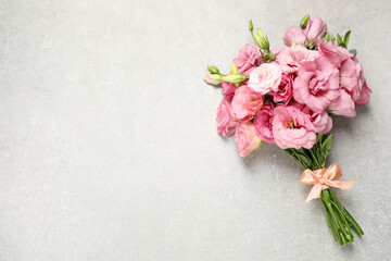 Beautiful bouquet of pink Eustoma flowers on light grey background, top view. Space for text