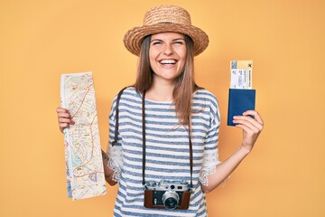 Beautiful caucasian tourist woman holding city map and passport smiling and laughing hard out loud because funny crazy joke.