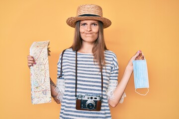 Beautiful caucasian tourist woman holding coronavirus safety mask skeptic and nervous, frowning upset because of problem. negative person.