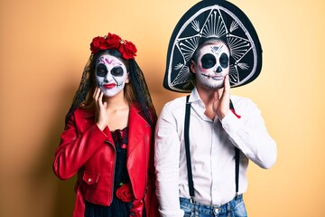 Couple wearing day of the dead costume over yellow touching mouth with hand with painful expression because of toothache or dental illness on teeth. dentist