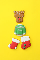 Different Christmas gingerbread cookies on yellow background, flat lay