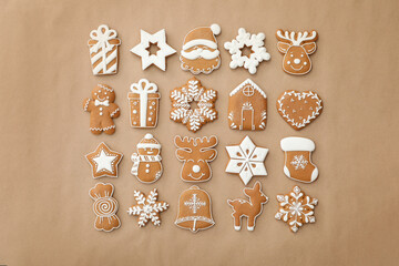 Different Christmas gingerbread cookies on brown background, flat lay