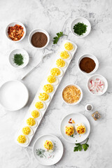 Top View of Deviled Eggs on a Deviled Egg Bar with Various Garnishes