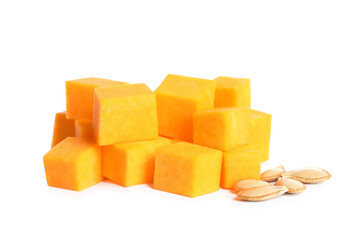 Pieces of ripe orange pumpkin and seeds on white background