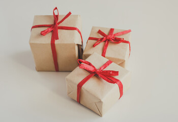Gift boxes made from craft paper with red ribbon on white background