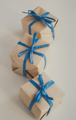 Gift boxes made from craft paper with blue ribbon on white background