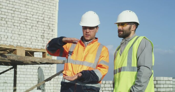 Builders speaking about work on construction site