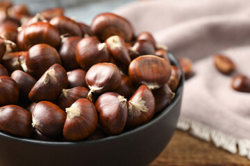 Obraz premium Fresh sweet edible chestnuts on table, closeup