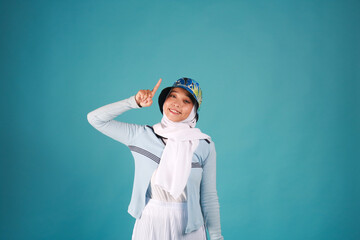 Fashion portrait of young beautiful asian muslim woman with wearing hijab on blue background. 