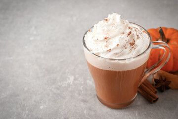 Delicious pumpkin latte on grey table, closeup. Space for text
