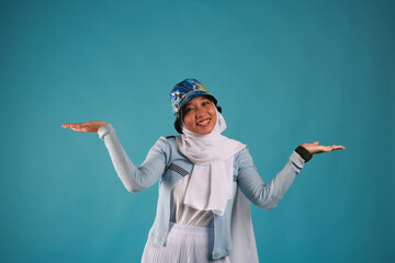 Fashion portrait of young beautiful asian muslim woman with wearing hijab on blue background. 