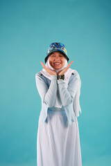 Fashion portrait of young beautiful asian muslim woman with wearing hijab on blue background. 