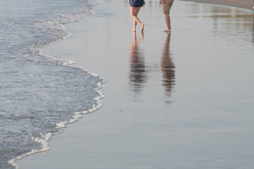 A couple walking on the beach.	