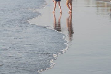 A couple walking on the beach.	
