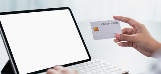 Hand holding a credit card and using tablet screen is blank. The concept of online shopping and payment.