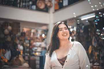 beautiful young woman with white dress blowing bubble