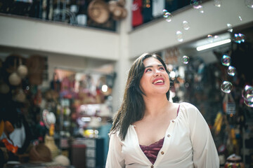 beautiful young woman with white dress blowing bubbles
