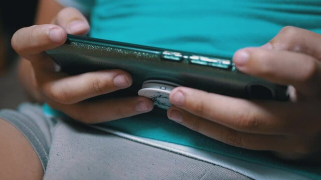 Boy Plays a Mobile Game on Smartphone at Home. Child in Hands a Holding Mobile Phone