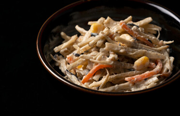 Burdock salad on a black background