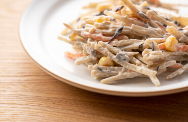 Burdock salad set against a wooden backdrop