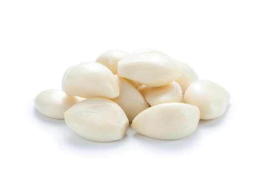 Pile of peeled garlic isolated on white background.