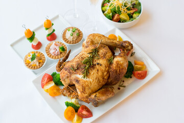 Whole roasted chicken and side dishes on white plate
