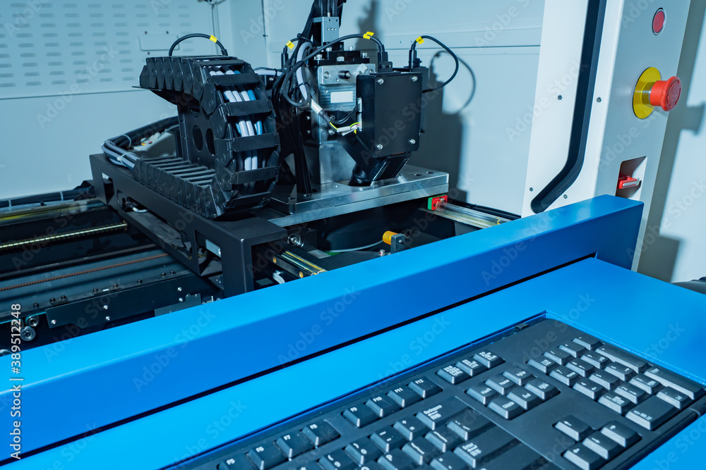 Aufkleber robotic manufacturing. cnc machine is behind the glass. keyboard for equipment control. concept is a