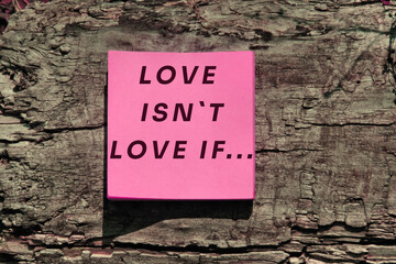 inscription Love isn`t Love if... on pink paper on  wrinkled bark surface  with deep cracks