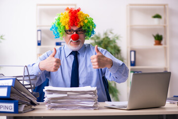 Old businessman clown working in the office