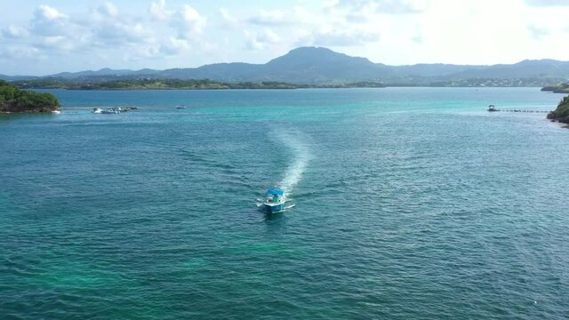 aerial back traveling over a boat going to a boat party between small islands in Martinique paradise destination 