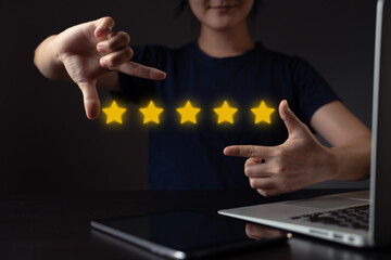 Woman using laptop present five stars icon hologram effect.