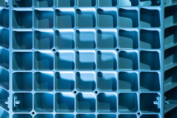 Industrial background. Light blue background with metal lattice. Metal latticeon industrial equipment. Abstract industrial texture. Metal lattice on production machine. Background on theme production