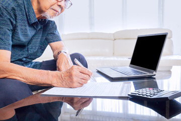 Old man hands filling home insurance form