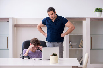 Young father and schoolboy playing computer games at home