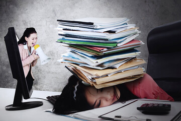 Angry boss reprimanding her exhausted employee